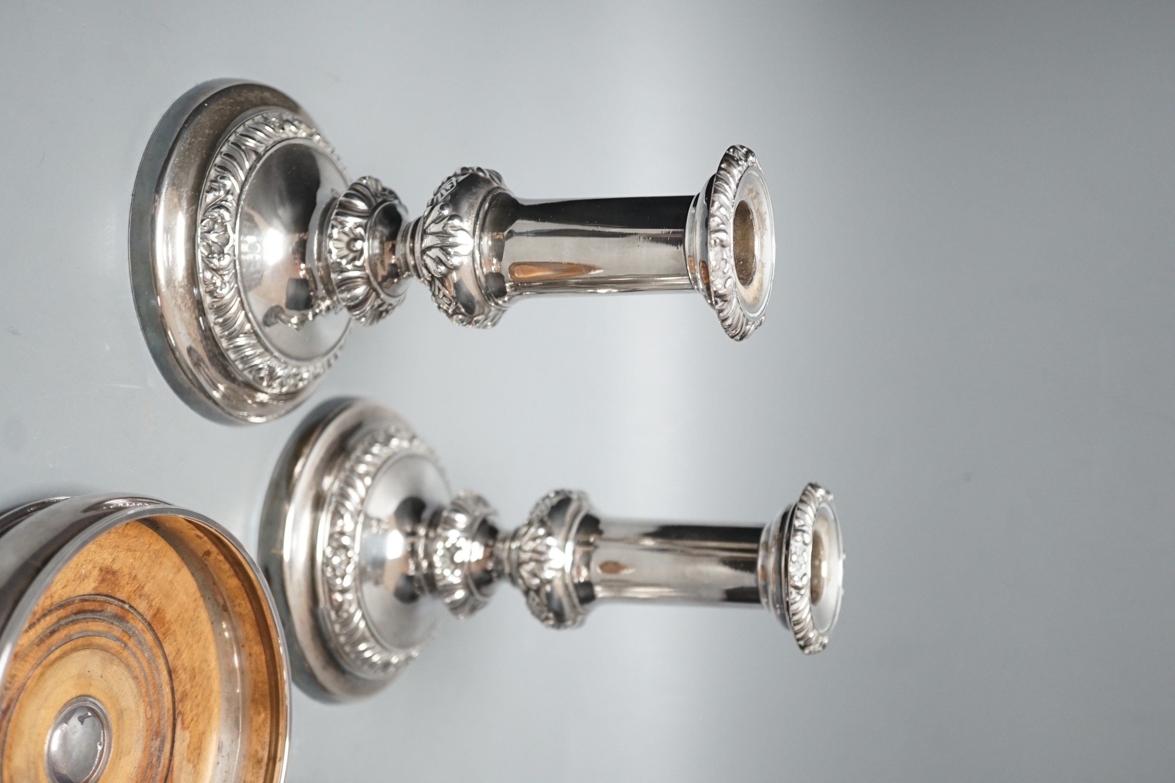 A modern silver mounted wine coaster, London, 1996, diameter 12.4cm, an earlier pierced silver bonbon dish and a pair of plated candlesticks.